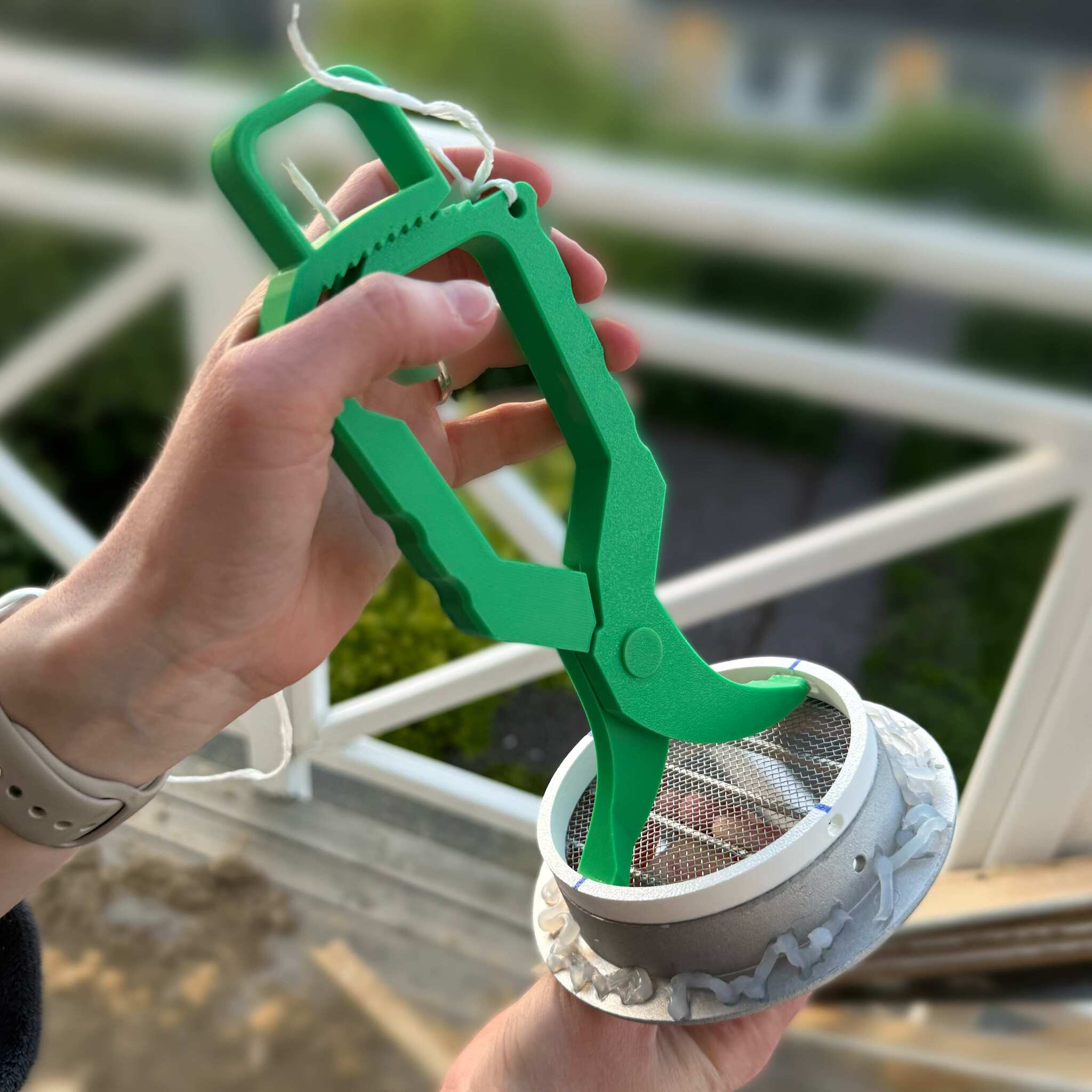 VTENG-verktyget i bruk - ett grönt specialverktyg som håller ett ventilationsgaller med fog applicerad